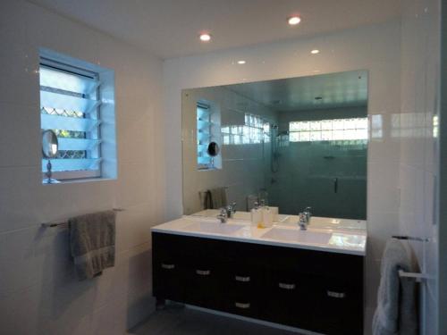 baño con lavabo y espejo grande en Sunset Quay, en Rarotonga