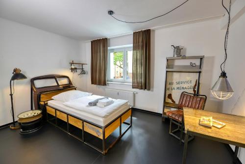 Hostel am Niederfeldsee في إيسن: غرفة نوم بسرير ومكتب وطاولة