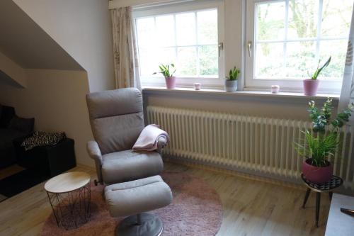 a living room with a chair and a window at Ferienwohnung Waldstuben in Goldenstedt