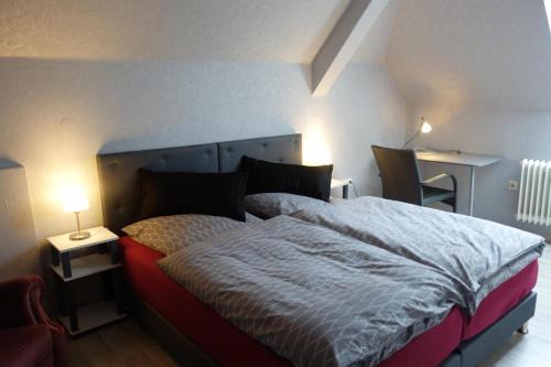 a bedroom with a bed and two tables and a lamp at Ferienwohnung Waldstuben in Goldenstedt