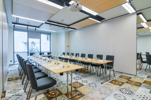 a conference room with a long table and chairs at ibis Styles Bucharest City Center in Bucharest