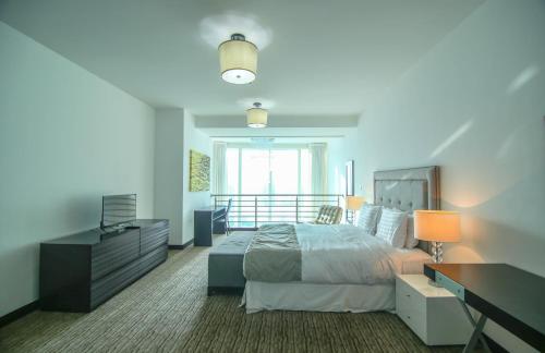 a bedroom with a bed and a desk and a bed sidx sidx sidx at Lux BnB Laguna Tower Penthouse JLT in Dubai