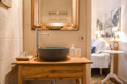 Hotel Aiguaclara في بيغور: حمام مع حوض على منضدة خشبية