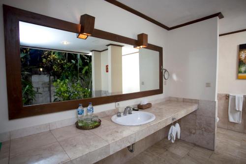 a bathroom with a sink and a large mirror at Natah Bale Villas in Sanur