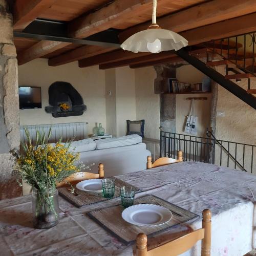 a dining room with a table and a couch at Les Cases De Borrells in Lladurs