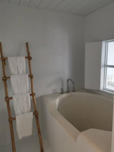 a bath tub in a room with a towel ladder at Ample Villa 小希臘民宿 in Ruifang