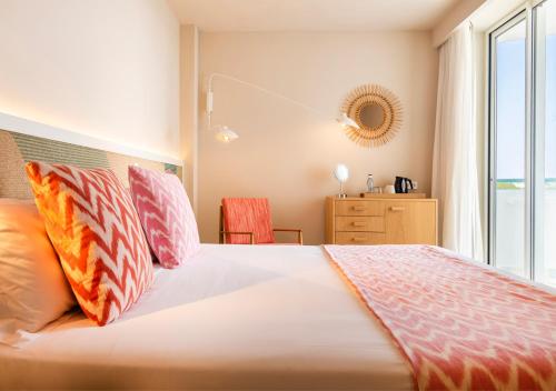 a bedroom with a bed and a dresser at Inturotel Cala Esmeralda Beach Hotel & Spa - Adults Only in Cala d´Or