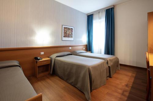 ein Krankenhauszimmer mit 2 Betten und einem Fenster in der Unterkunft Hotel Esperia in Rho