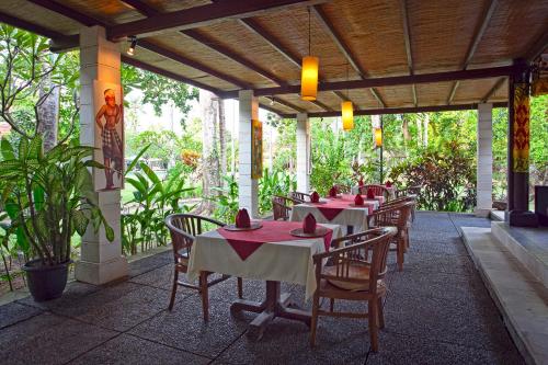 a restaurant with tables and chairs on a patio at Natah Bale Villas in Sanur
