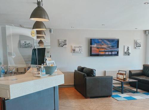 a living room with a counter with a couch and a table at Mode Hotel St Annes in Lytham St Annes