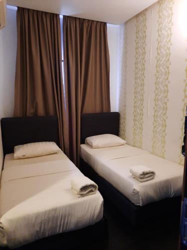 two beds sitting next to each other in a room at Hotel Cipta Impian in Kampong Keriting