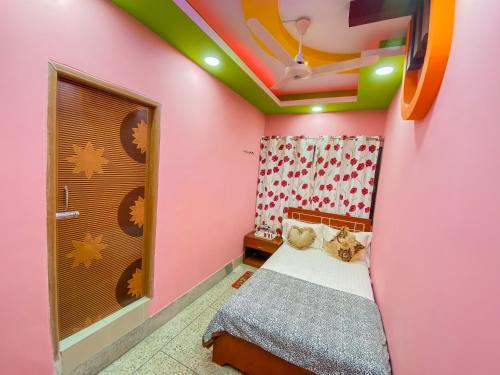 ダッカにあるHotel As Shams Internationalのピンクの壁の小さなベッドルーム(ベッド1台付)