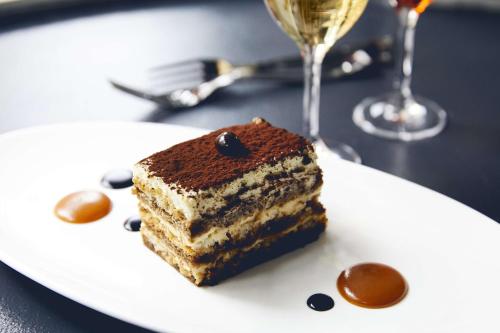 a piece of cake on a plate with a glass of wine at Kimpton Hotel Monaco Denver by IHG in Denver