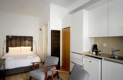 um pequeno quarto com uma cama e uma cozinha em Flats Castelo - HOrigem em Lisboa