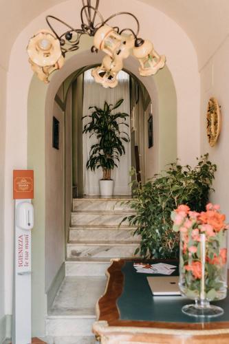 a hallway with a table with flowers and a chandelier at B&B Diana in Cittanova