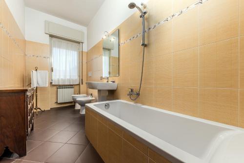 a bathroom with a tub and a sink and a toilet at Casa da Suite Duchessa in Stresa