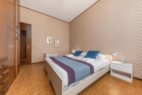 a bedroom with a large bed with blue pillows at Casa da Suite Duchessa in Stresa