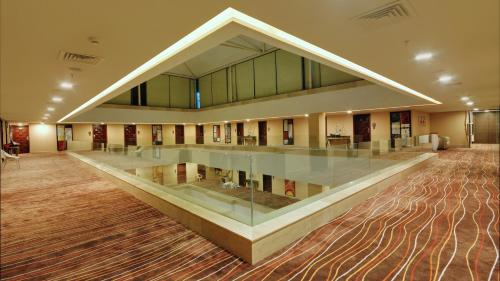 a large lobby with a large glass table in the middle at The Fern Residency Rajkot in Rajkot