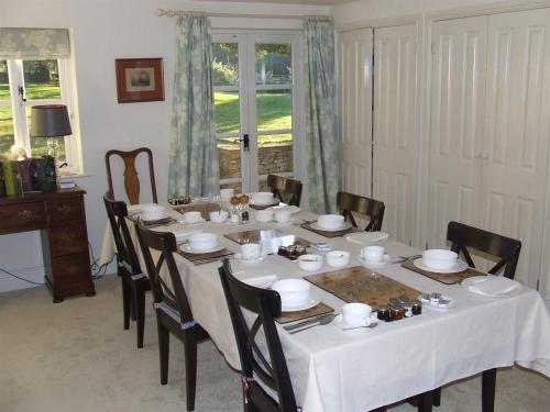 a dining room with a white table and chairs at Well Cottage B and B in Cirencester