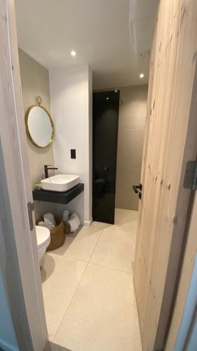 a bathroom with a sink and a toilet and a mirror at Abacus Suites in Ayia Napa