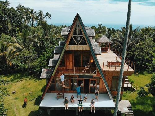 a group of people standing outside of a house at Camiguin Volcano Houses - A-Frame house in Mambajao