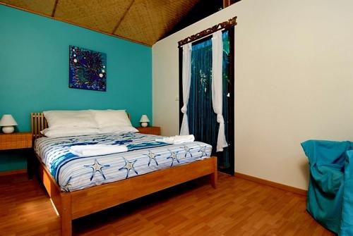 a bedroom with a bed with blue walls and a window at Byron Bay Accom 2B Manfred St - The Wave House in Byron Bay