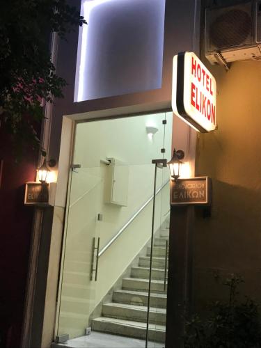 a hotel entrance with a sign on the door and stairs at Elikon in Athens