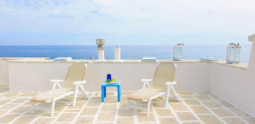 2 sedie e un tavolo sul balcone con vista sull'oceano di Casa Corallo a Villanova