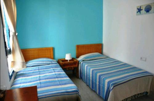 2 Betten in einem Zimmer mit blauen Wänden in der Unterkunft Casa el mar in Costa Teguise