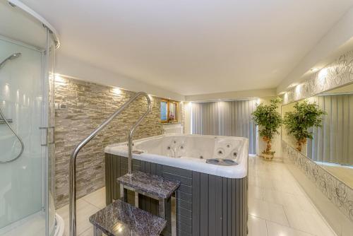 a large bathroom with a tub and a shower at Dom wczasowy Anna Maria in Sierockie