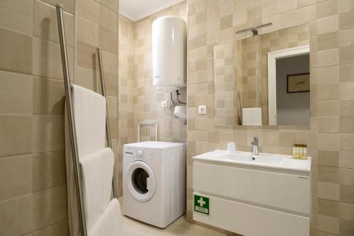 a bathroom with a washing machine and a sink at Flats Castelo - HOrigem in Lisbon
