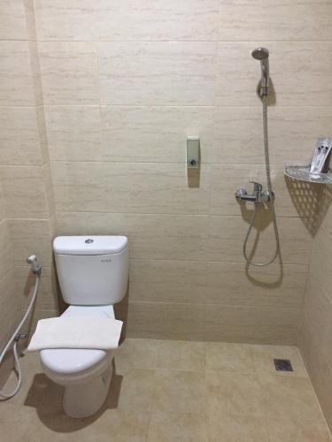a bathroom with a toilet and a shower at Padadita Beach Hotel in Waingapu