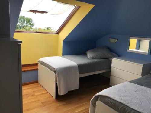 a bedroom with two beds and a window at Apartamento Tere in Llanes