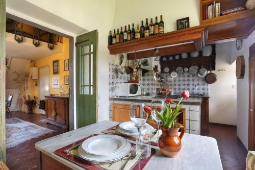 een keuken met een tafel met borden en glazen erop bij A Postcard View in a Vintage Apartment in Florence