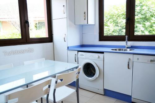 a kitchen with a sink and a washing machine at Chalet Tina Mayor: amplio jardín y tranquilidad muy cerca de la playa in Pesués