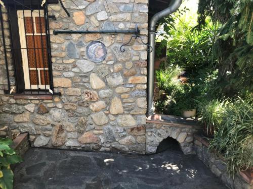 a stone wall with a water fountain in a garden at Hébergements à La Rive, Accueil ouvert tous les jours jusqu'à 20h00 dernier délai, depuis 30 ans ! Réserver ici svp ! Merci ! Aucun règlement à distance accepté, Paiement par CB, Espèces, Chèque ou Chèques-Vacances impérativement à la remise des clefs ! in Amélie-les-Bains-Palalda
