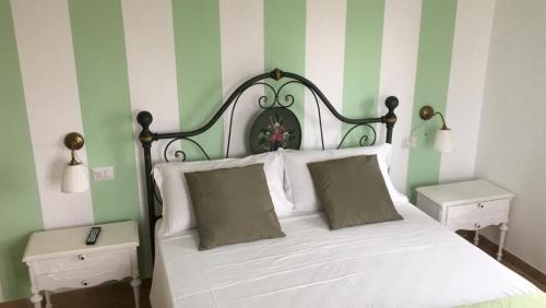 Schlafzimmer mit einem Bett mit Grün- und Weißstreifen in der Unterkunft La dolce vita in Porto Recanati