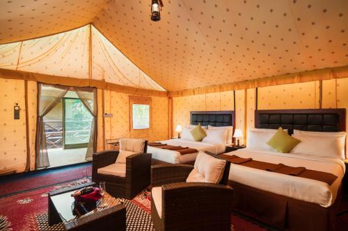 1 dormitorio con 2 camas, sofá y sillas en Fun Retreat Resort, Hotel and Ayurveda Spa en Arusha