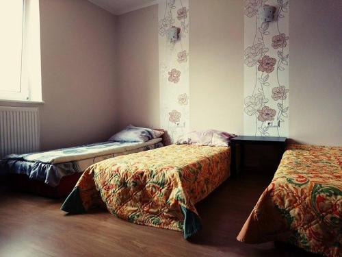 Cette chambre comprend 2 lits et une fenêtre. dans l'établissement MHostel, à Piaseczno