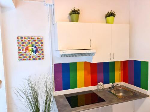 巴塞隆納的住宿－Arc House Gracia，彩虹厨房设有水槽和色彩缤纷的墙壁