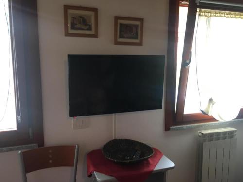 Habitación con TV de pantalla plana en la pared en HOME PREDIL en Tarvisio