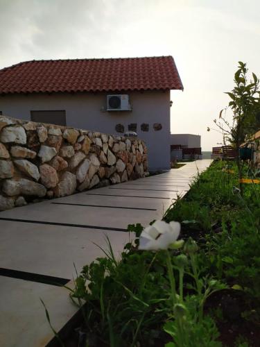 a stone wall next to a house with a walkway at נוריות בגלבוע 2 in Nurit