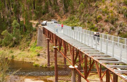 a bridge over a river with people walking on it at Walhalla's Star Hotel in Walhalla