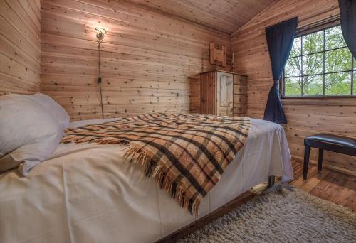 um quarto com uma cama num chalé de madeira em Bungalow in Sirdal em Tjørhom
