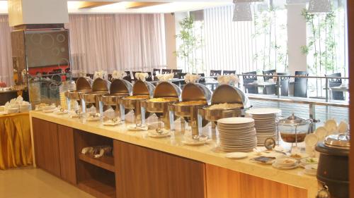 a buffet line with plates and dishes on it at Winstar Hotel in Pekanbaru