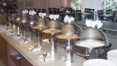 a buffet line with a bunch of pans of food at Winstar Hotel in Pekanbaru