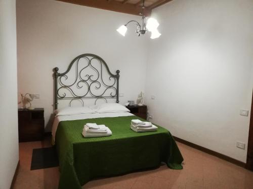 um quarto com uma cama com um cobertor verde em B&B Al Borgo em Corciano
