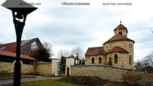 a church with a tower and a brick wall at Guest House Prague Airport in Prague