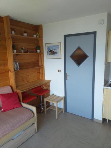 a bedroom with a bed and a desk and a door at La Voile - Pendine 2 - Puy Saint Vincent - Hautes Alpes in Puy-Saint-Vincent