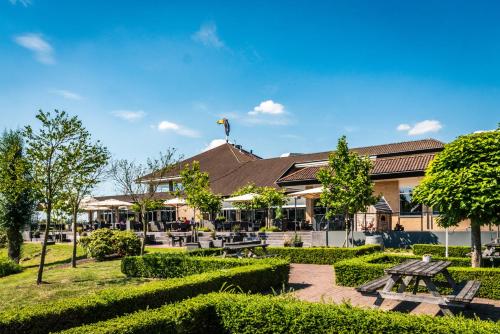 un parque con bancos y árboles frente a un edificio en Van der Valk Cuijk - Nijmegen, en Nijmegen